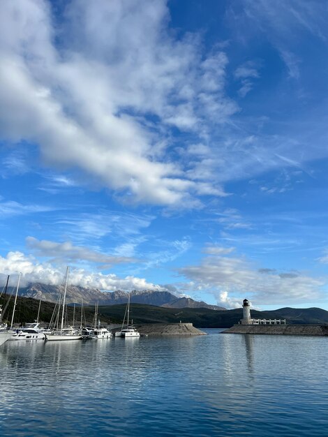 Yachts moored at the breakwater with a lighthouse at the foot of the mountains