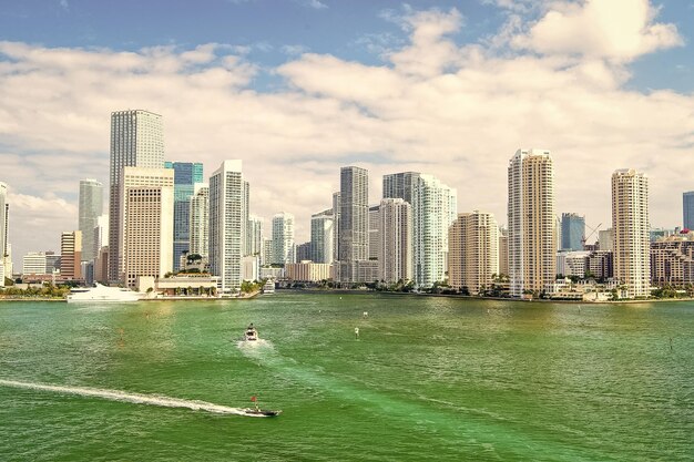 Yachts sail on sea to city skyscrapers in Miami USA