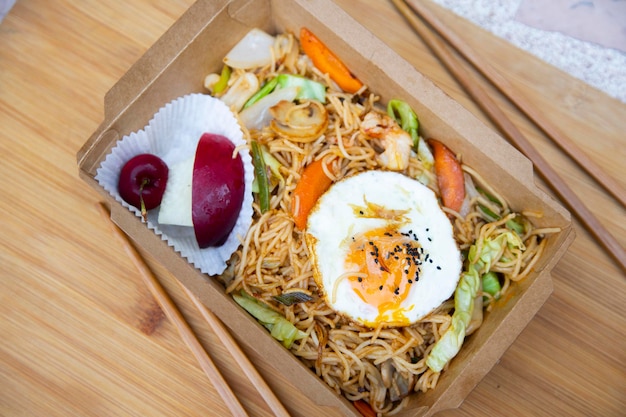 Yakisoba noodle dish with seafood and a fried egg. Typical Japanese combo plate.