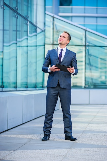 Yang businessman works with tablet computer outdoors.