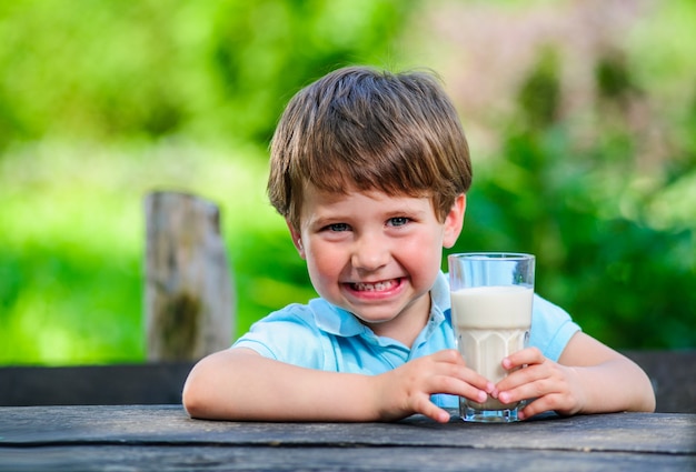 Yang kleine en schattige jongen afgebeeld met glas melk.