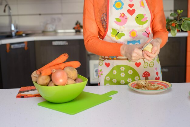 Photo yang woman grab potato by hand in the kitchen