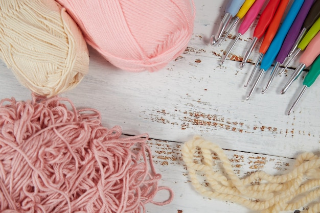 Yarn for crocheting and hooks on a wooden background. Flatlay concept.