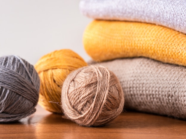 Yarn and knitwear on wooden table