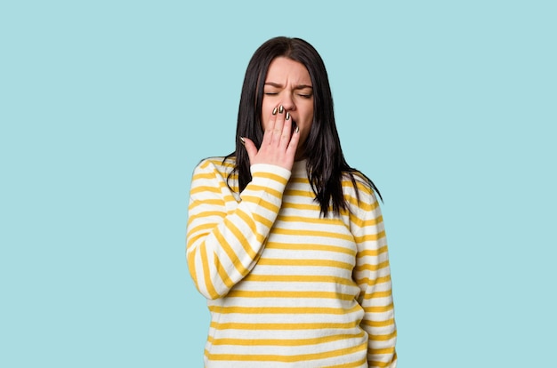 Yawning showing a tired gesture covering mouth with hand