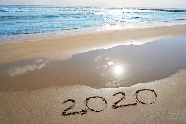 Photo year 2020 numbers spell written on beach