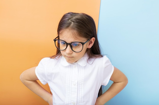 A yearold girl with glasses with an angry face and hands on her sides childrens education learning c