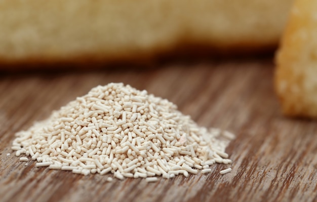 Yeast with bread on wooden surface