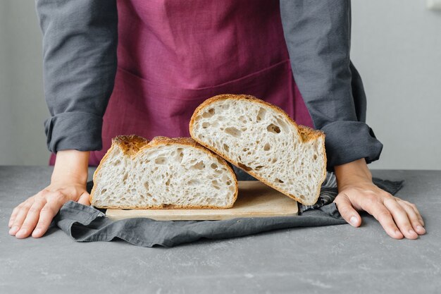 Yeastfree sourdough bread a beautiful european woman baker\
holds bread in her hands