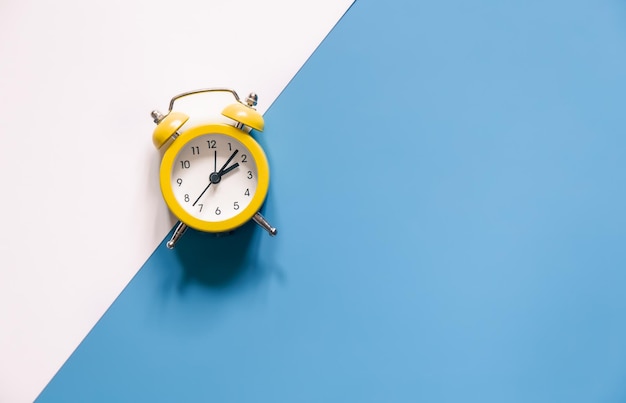 Yellow alarm clock on colored background isolated flat lay