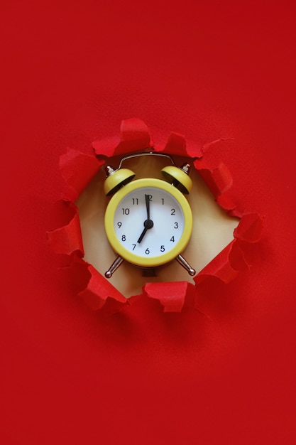 Yellow alarm clock from the paper hole