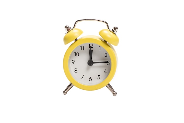 Yellow alarm clock isolated on a white wall.