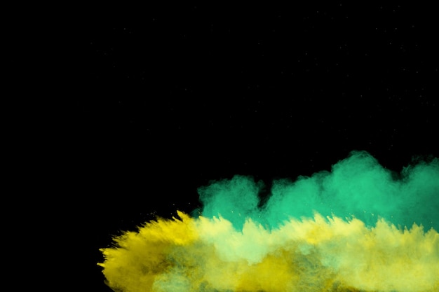 Фото Взрыв желтой и зеленой пыли на черном фоне