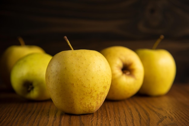 Yellow apples, on the dark wooden background. Copy space.