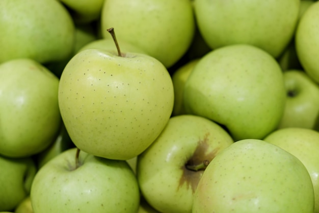 Yellow apples of the Golden Delicious variety on counter of farmers market. Fruits are large, with yellowish-green skin, and have sweet taste. Natural products, seasonal fruits, local food.