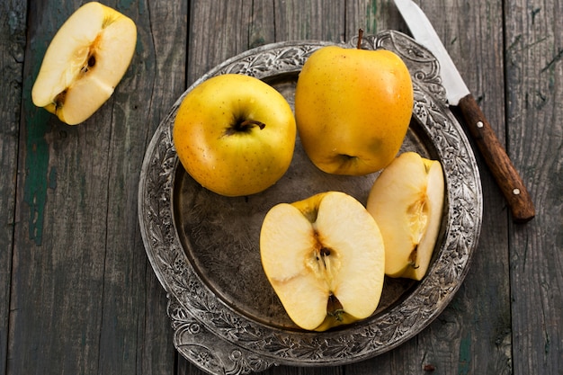 Yellow apples on a metal tray in rustic style