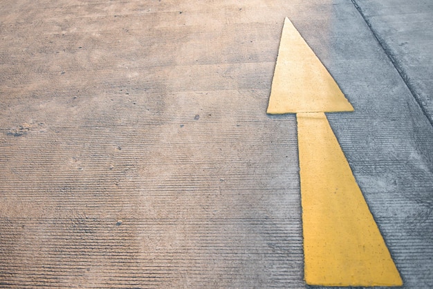 Yellow arrow on the road in the evening