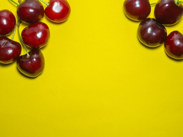 Yellow background and ripe cherries berries on yellow juicy fruit ingredient for compote