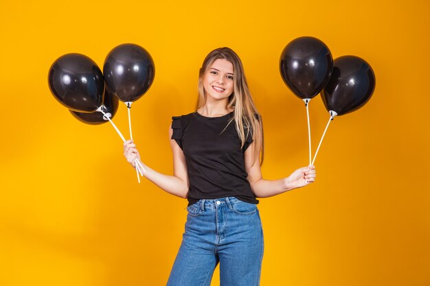 On yellow background with air balloons studio portrait. Black friday sale