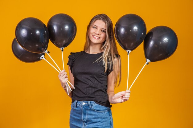 On yellow background with air balloons studio portrait. Black friday sale