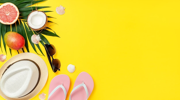 Yellow background with summer accessories. Travel and lifestyle concept. Flat lay, copy space.