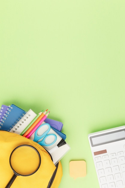 Yellow backpack with notebooks and study supplies