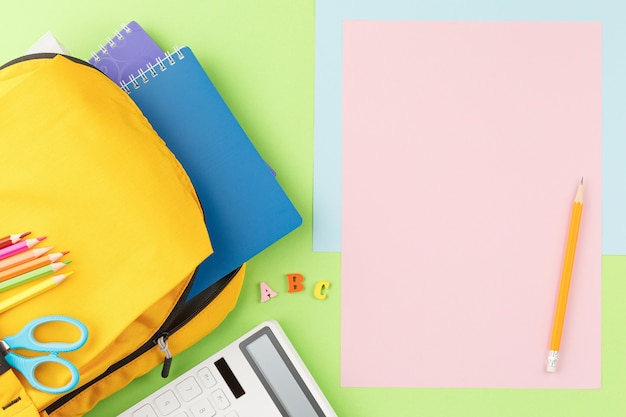 Yellow backpack with notebooks and study supplies