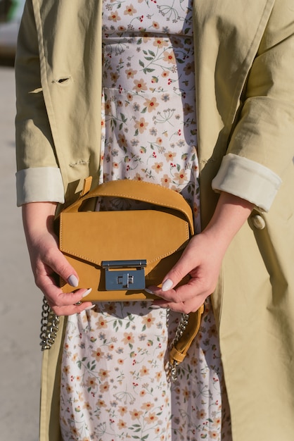 Yellow bag in the hand of a girl in the sun