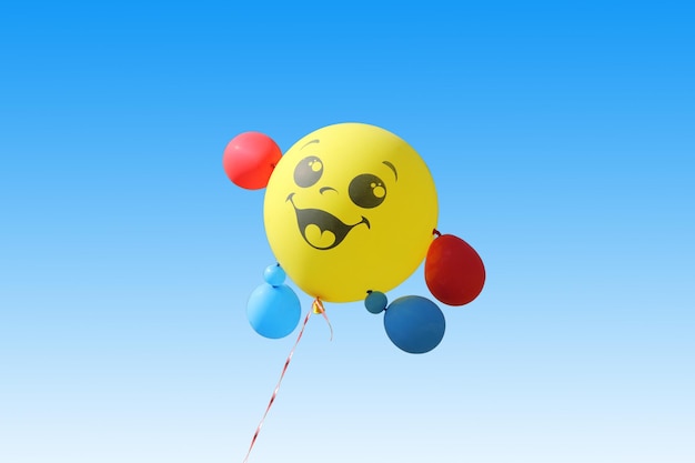 Photo yellow balloon flying on a blue sky background