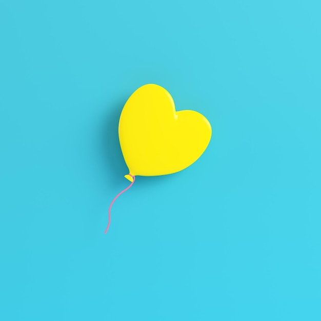 Yellow balloon in heart shape for valentines day on bright blue background in pastel colors