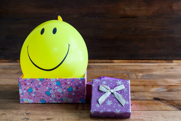 Yellow balloon with smile and gift box