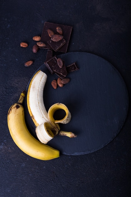 Yellow banan on black background. Exotic food concept Fruit minimal concept. Flat lay.