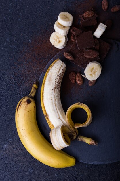 Yellow banan on black background. exotic food concept fruit\
minimal concept. flat lay.