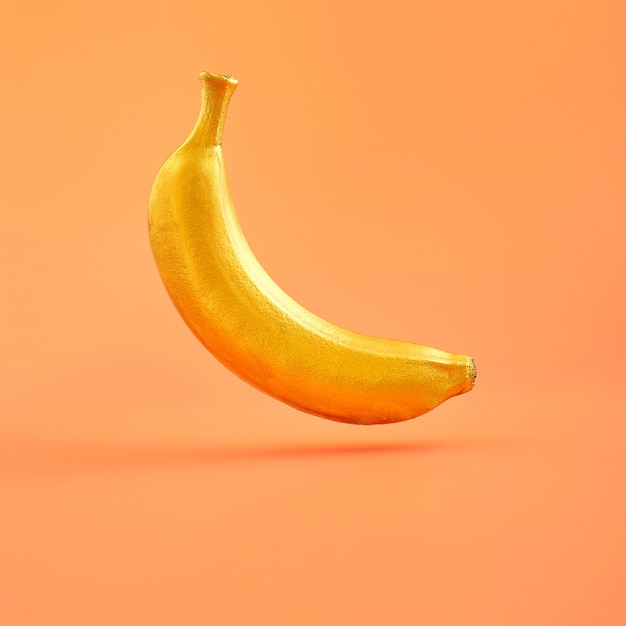 yellow banana on bright light orange background