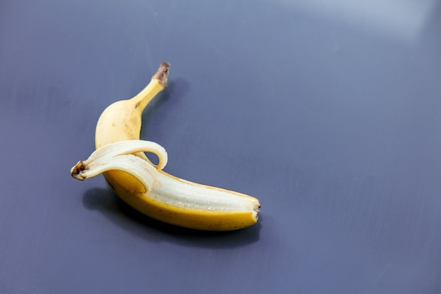 Yellow banana on grey metal background. Above view