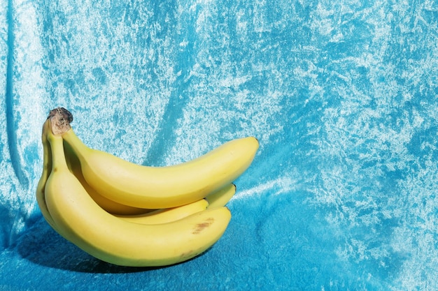 Желтые бананы на голубой ткани