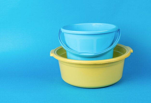 Photo a yellow basin and a blue bucket on a blue background