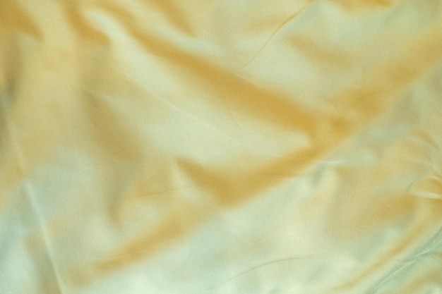 Yellow bed linen gradient texture blurred curve style of abstract luxury fabricWrinkled bed linen and gold shadowsbackground