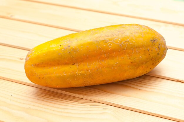 Photo yellow big cucumbers on wooden cutting plate