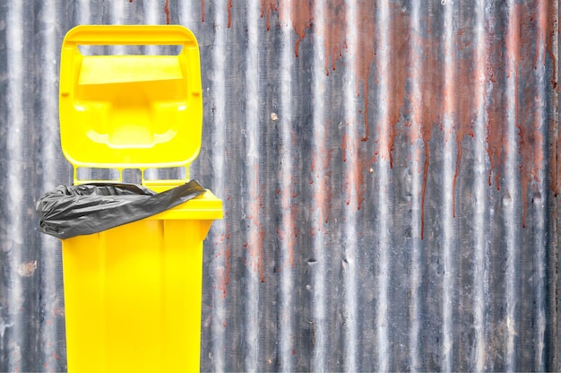 Yellow bin on background old zinc textured