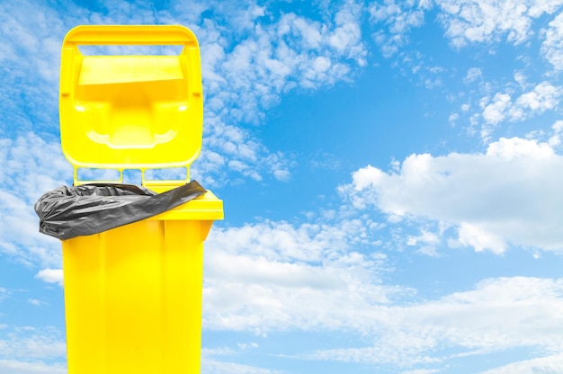 Yellow bin on blue sky background