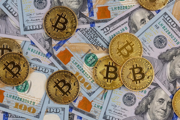 Monete bitcoin gialle sparse su banconote di carta in dollari usa criptovaluta e concetto di scambio di denaro fiat