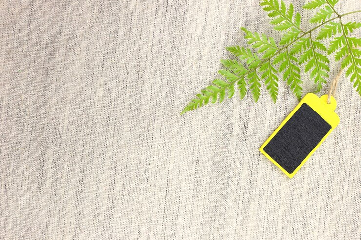 Yellow and black blank wooden tag with leaves on fabric
