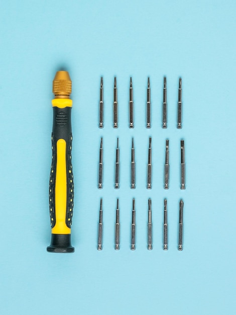 Photo yellow and black screwdriver and a set of attachments for repairing mobile devices accessories for repair