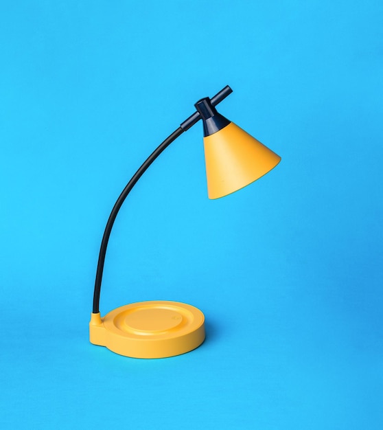 Yellow and black table lamp on a blue background Desktop lighting