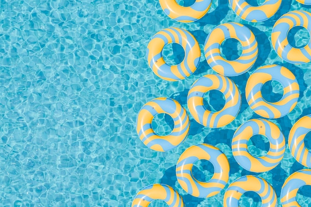 Foto anelli gonfiabili gialli e blu che galleggiano in piscina