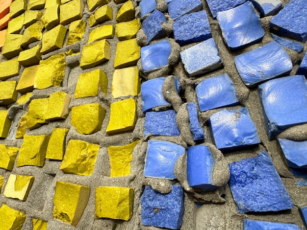 Photo yellow and blue stones are smeared on the wall