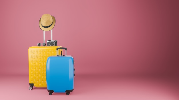 Yellow and blue suitcase with sun hat and glasses camera on pastel pink