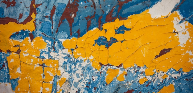 黄色、青、白、茶色の抽象的なヴィンテージの背景。木の表面の古い剥離塗料、風化した質感。