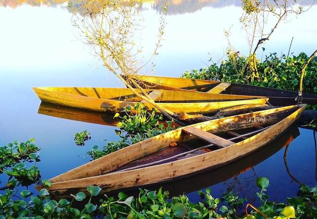 Photo yellow boat moored by lake against sky